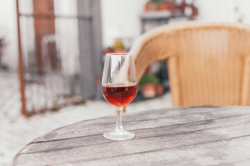 A glass of orange moscatel wine from Setubal on a wooden table on a terrace 