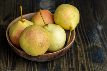 Ripe yellow pear with red shades covered with drops of pure water