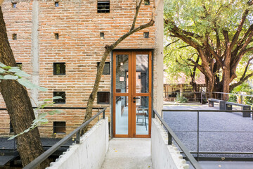 Wooden door with brick wall house in forest.