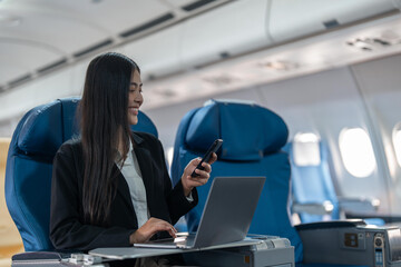 transport, tourism and technology concept of business woman with smartphone and laptop traveling by plane