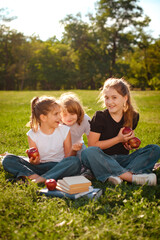 happy children play and have break in park after school classes on green trees background