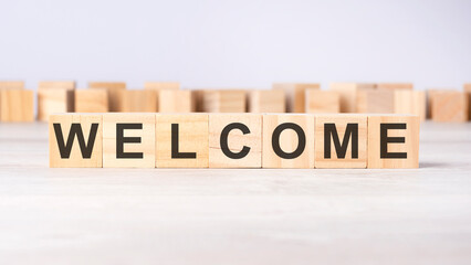 word WELCOME inscribed on wooden cubes lying on a light table. economy and investments concept.