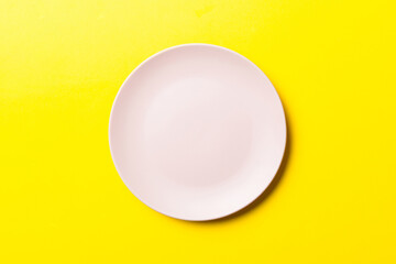 Top view of isolated of colored background empty round pink plate for food. Empty dish with space for your design