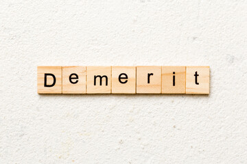 demerit word written on wood block. demerit text on table, concept