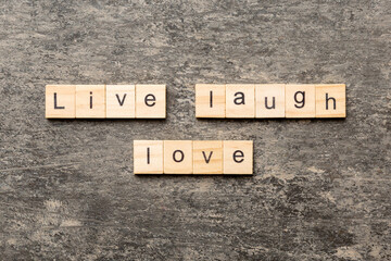 Live laugh love word written on wood block. Live laugh love text on cement table for your desing,...