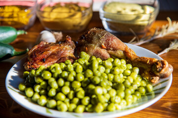 Roasted delicious chicken with vegetables...peas...wooden table