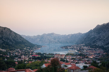 Aerial view of famous Kotor bay with picturesque rocks, old town and cruise ship at the port.