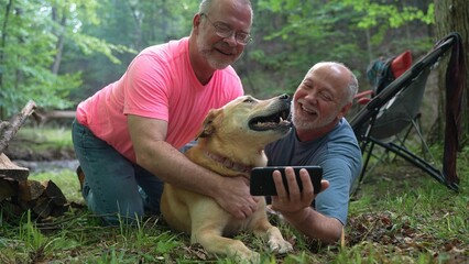 Playful Blonde Labrador Retriever dog sharing love with funny man holding phone taking a selfie in...