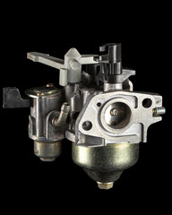 Carburetor, part of a gasoline internal combustion engine, spare part, isolated on a black...