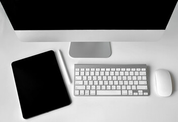 Computer devices with digital tablet for works on white desk.