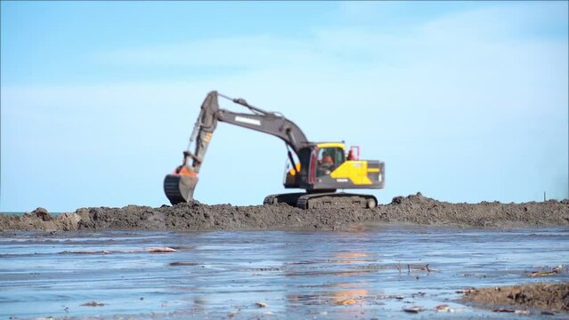 Excavator works on the nourishment of the sandy coast