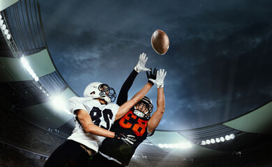 Dynamic shot of male sportsmen, professional american football players during game, catching ball....