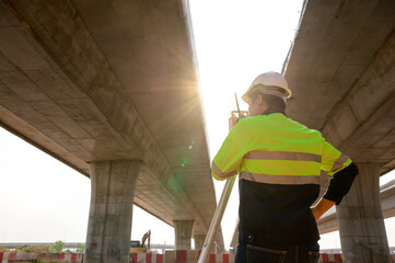 Surveyor Engineer using a theodolite in the construction of a motorway bridge Engineer working with...