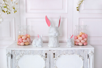 Interior design of living room interior with wooden dresser, stylish easter bunny sculpture and...