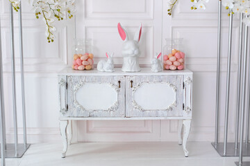 Interior design of living room interior with wooden dresser, stylish easter bunny sculpture and...