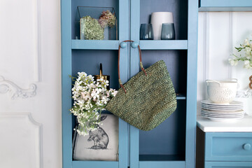 The minimalist interior design of the Scandinavian kitchen is decorated with a hanging wicker bag...