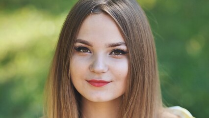 Portrait of a young girl in a park. Close-up of her face.