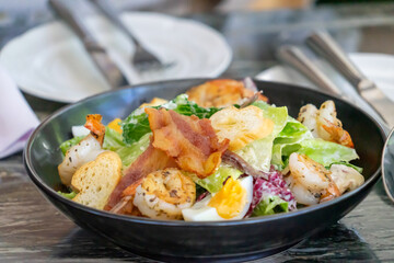 Fototapeta na wymiar Delicious Caesar Salad with Grilled Chicken, Crispy Bacon, and Shrimp