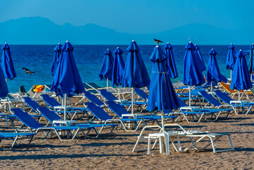 Sunbeds and umbrellas at a beach in Rhodes town in Greece