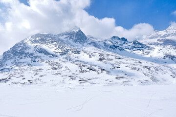 Bernina mountain pass. The famous red train is crossing the white lake. Amazing landscape of the Switzerland land. Famous destination and tourists attraction