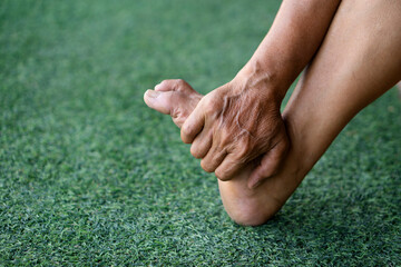 Closeup eldely woman hand massage foot. Concept, first aid for foot cramp, sprain or numbness. Therapy or treatment to relife painful. Self basic take care. Health problems and health care. 