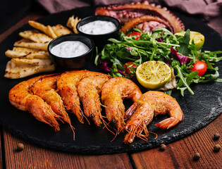 Traditional greek grilled seafood on restaurant wooden plate