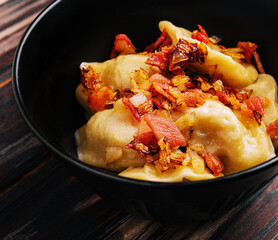Baked potato dumplings with fried bacon and onions