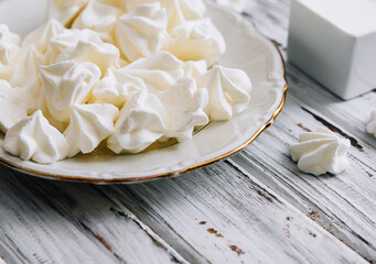 Meringue cookies in in a plate on wood