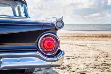 Heck von einem klassischen, blauen Cadillac am Strand