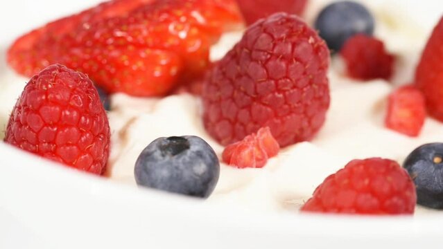 uno yogurt grecco con frutti rossi sopra, yogurt con lamponi fragole e mirtilli

