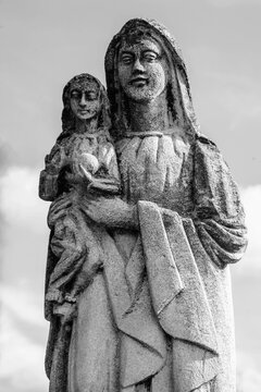 Very ancient stone statue of the Virgin Mary with the baby Jesus Christ. Religion, faith, eternal life, God, the soul concept. Vertical image.