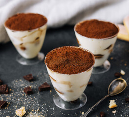 Italian dessert tiramisu in glass and eclairs with chocolate slices