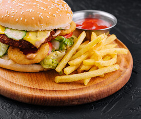 Juicy burger with onion rings and french fries