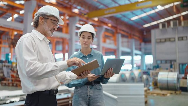Two engineer manager leader and woman assistant holding laptop and shaking hands for making together after processes order at metal factory