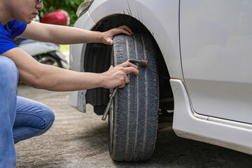 The young man checks the tires before leaving to ensure the journey. © ArLawKa
