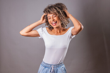 beautiful Brazilian woman, black,.messing with her hair, afro hair. showing curls.