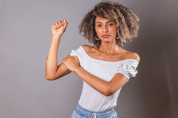 Brazilian black woman, with high clenched fist, feminist position, struggle, female empowerment.