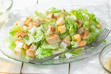 Caesar salad in a glass plate close-up