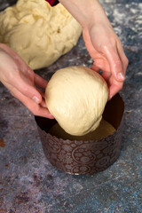 Confectioner lays the dough in form for baking Easter cakes