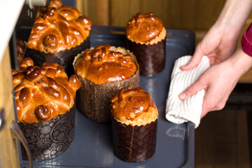 Easter cake. The confectioner pulls out baked Easter cakes from the ovens