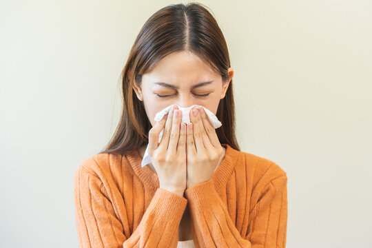 Sick, Coronavirus covid asian young woman, girl have a fever, flu, hand in use tissues paper sneezing nose, runny and cough, standing on isolated background. Health care to disease influenza seasonal