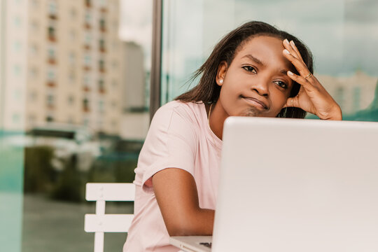 Tired exhausted overworked african american woman hipster sitting outside with laptop. Young entrepreneur freelancer student businesswoman failure low energy need to sleep have a rest chill

