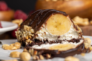 Fresh sweet cake with banana in chocolate glaze and milk filling