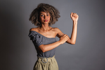 Brazilian black woman, high clenched fist, sign of militancy, feminism, fight against racism and...