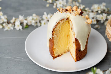 Piece of Easter cake on plate decorated with spring flower branches