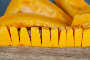 Sweet ripe orange pumpkin is sliced on the table