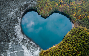 Heart shape lake in winter and summer, photomontage using two photos.