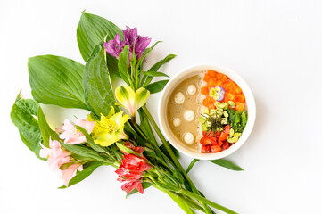 Salmon poke on a white background decorated with bright flowers