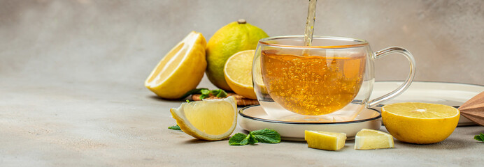 Bergamot tea in transparent cup with fresh bergamot fruit, Clean eating, dieting, vegan food concept. Long banner format - obrazy, fototapety, plakaty