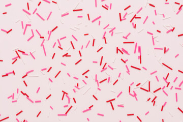 flat lay of pink sprinkles over background, festive decoration for banner, poster, flyer, card, postcard, cover, brochure, designers